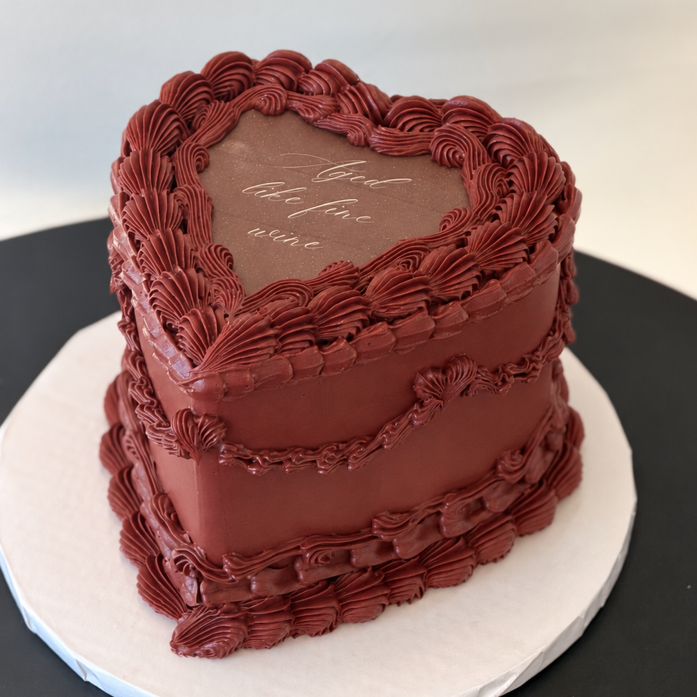 burgundy heart-shaped cake with vintage piping and a calligraphy message on top