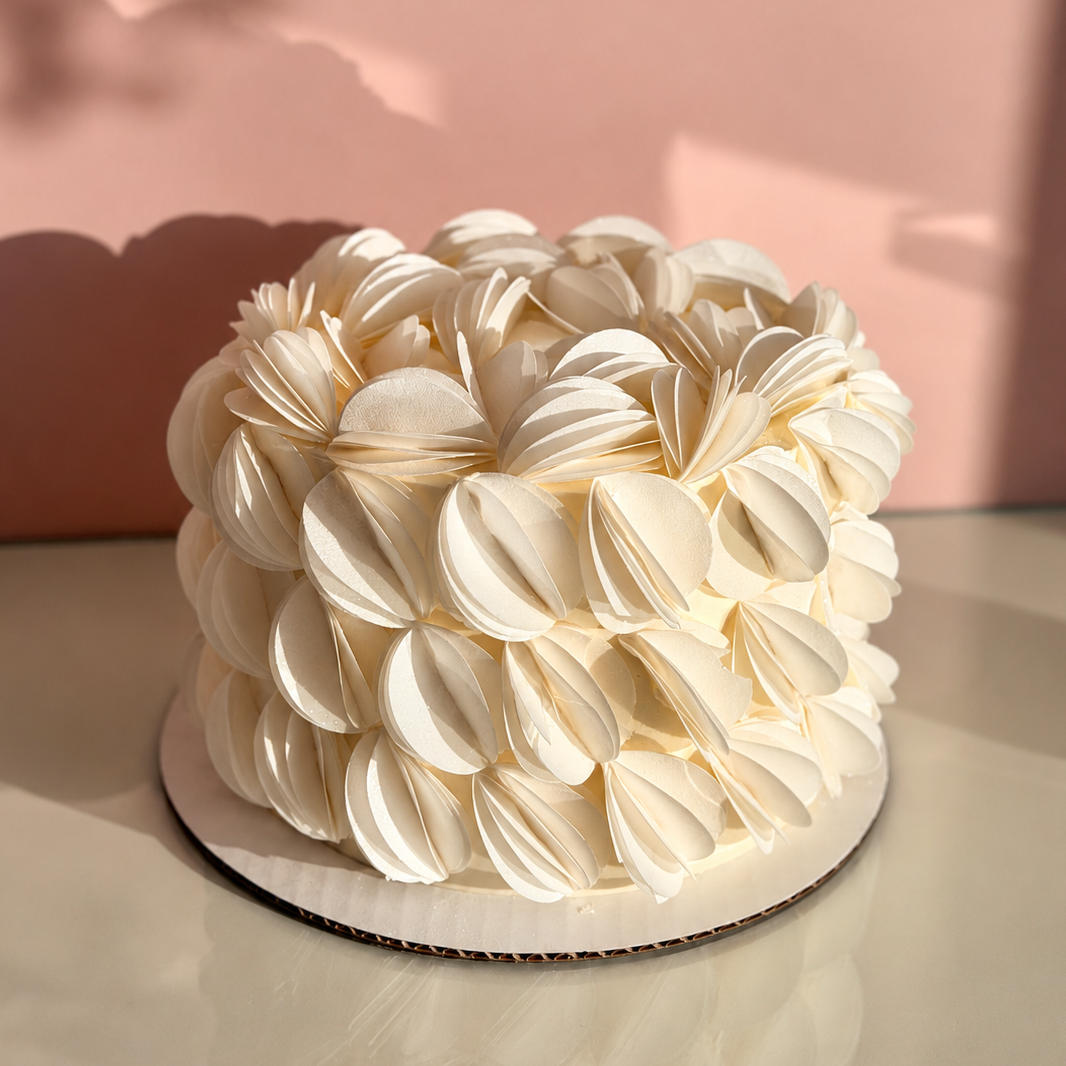 ivory cake covered in large petal-like decorations