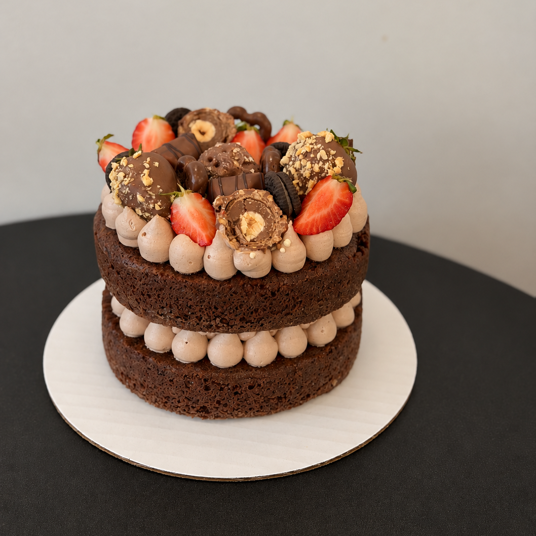 semi-naked dark layer cake with cream dollops, strawberries and round sweets on top